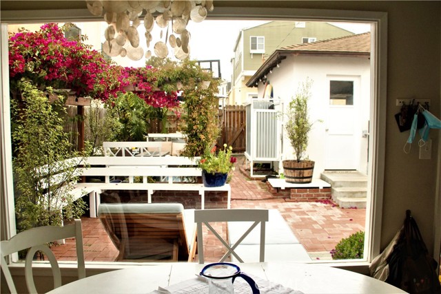 Looking out at charming patio/yard area from inside dining area. Garage is on right and is a 2 car garage with alley access.