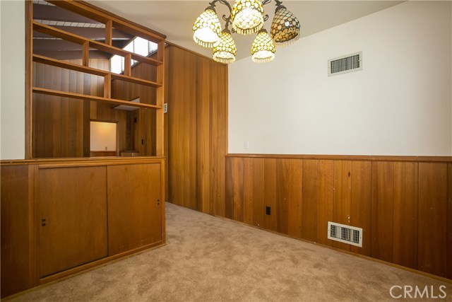 The dining room which is well sized and adjoins the kitchen is separated from the living room by the wooden wall storage cabinet.