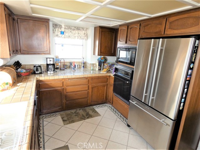 Large kitchen with custom tile floor, oak cabinets, dish washer, double sinks, trash compactor, double ovens & microwave.