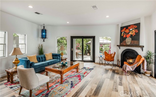 Main family room which is open yet warm & features a cozy fireplace with distressed wood mantle.