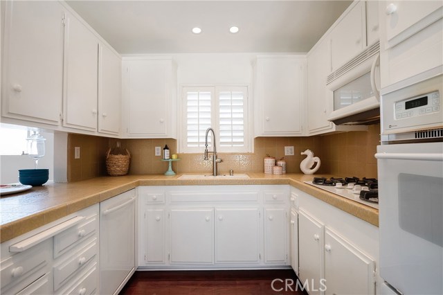 Open kitchen with recessed lighting and shuttered window.