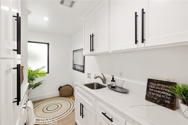 Spacious Laundry Room With Utility Sink and Plenty of Storage Space