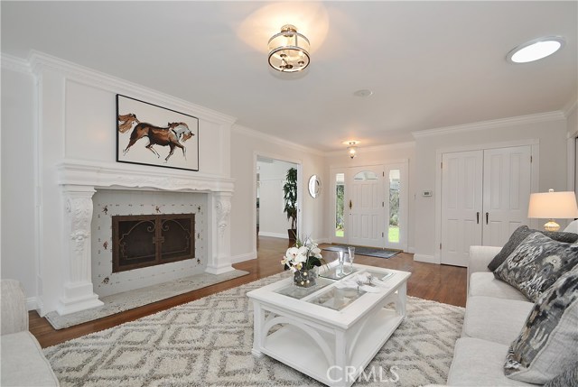 Living room with fireplace, crown molding, custom mantel, looking towards front entry