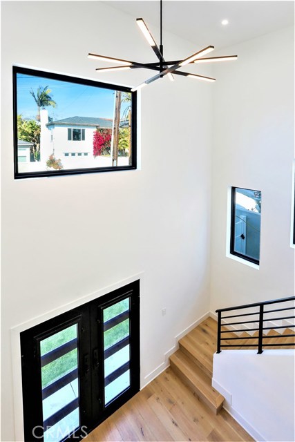 You enter through Custom Metal Double Doors into the Spacious Entry with Soaring 18' High Ceilings which leads to the Great Room. The Surrounding Windows Flood this area with Light. The Light Fixtures, Black Metal Railings and Trim, complement the Contemporary Design