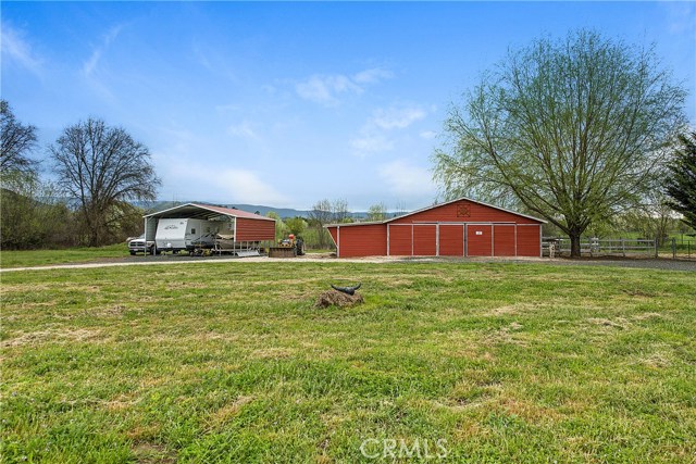 Newer carport & large barn with tack room, horse stall & more