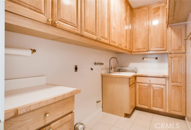 Spacious, dedicated laundry room features plenty of storage.