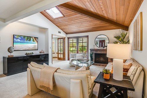 Wood Beamed Ceiling Living Room with Skylight opens to lovely patio