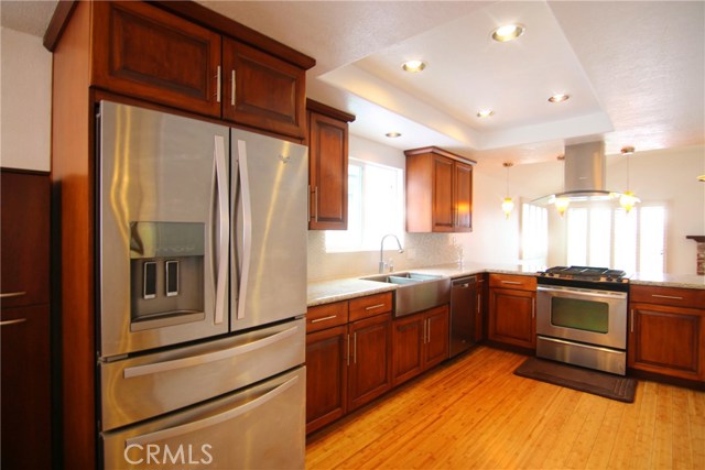 Remodeled kitchen on top floor with granite counter tops, glass backsplash, upgraded cabinets, Whirlpool fridge, dishwasher and stove with hood.