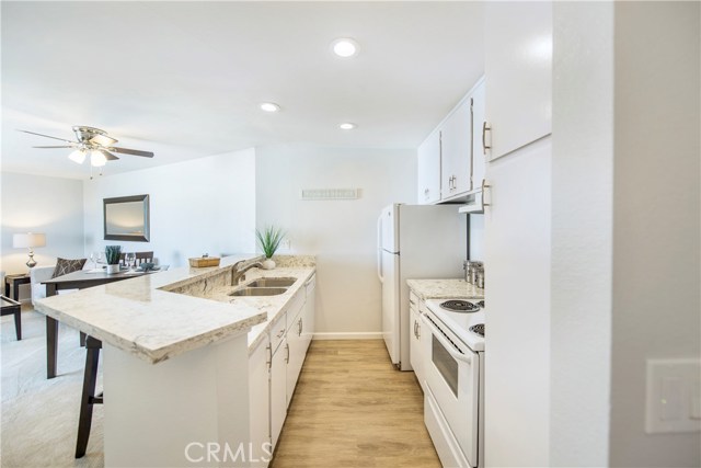 Extensively remodeled with quartz countertops, recessed lights, new flooring throughout, new lighting, smooth coat ceiling and the kitchen wall removed to have a bright an open layout