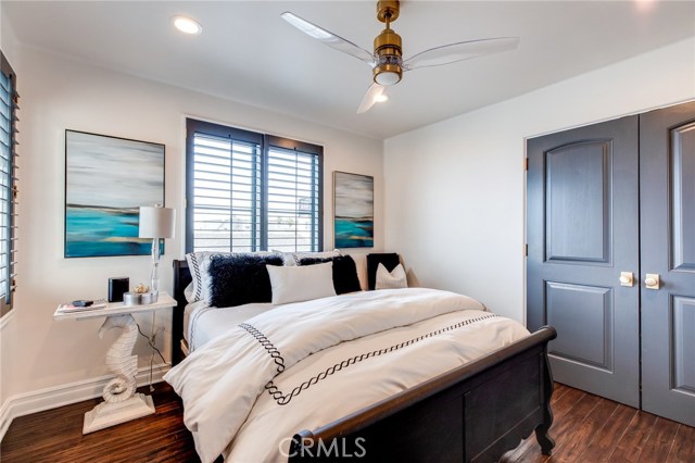 This bedroom also features a ceiling fan and a large custom closet