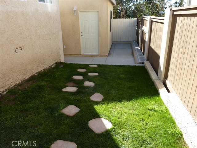 Green back grassy area near garage leading to office