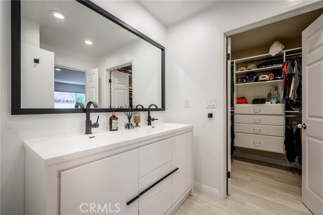 Master bath room with large walk in closet with built ins
