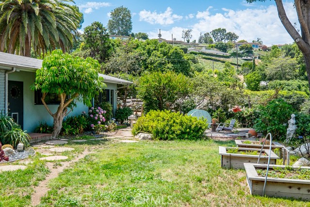 Back yard with flower beds leading to horse stables