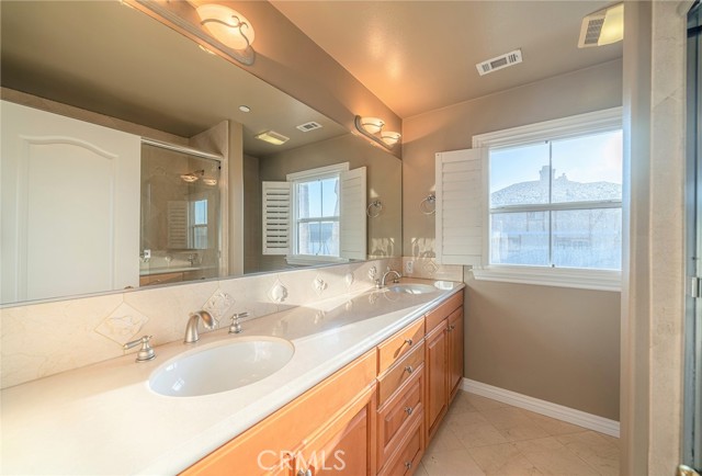Full Bath featuring dual vanity sinks with custom tile work