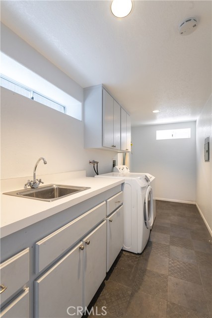 Lower level laundry room with lots of cabinets and a counter for folding your laundry.