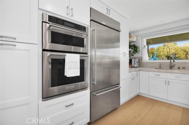 This area is all new! Top of the line kitchenaid frig and ovens need more space... new shelving, drawers, and pantry were installed! Now you can feel free to move about the kitchen!