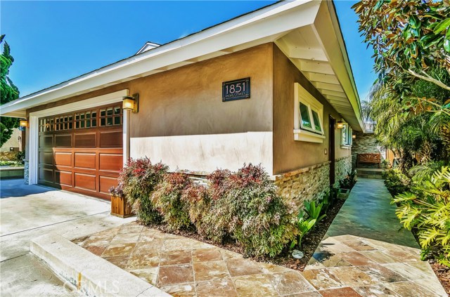 The exterior of the home has been remodeled with Santa Barbara smooth stucco, slate stone entry way pavers, and rich wooden doors and fencing.