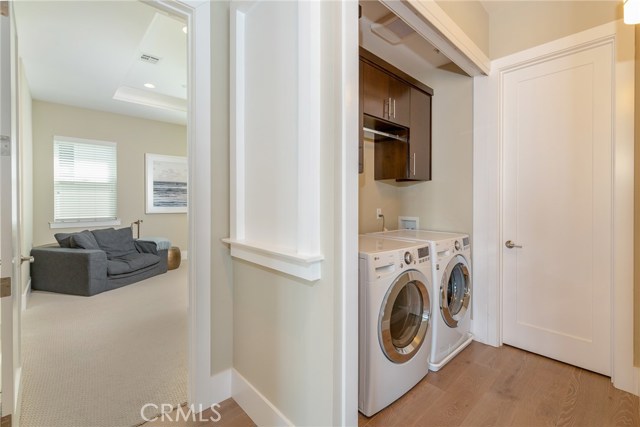 Laundry space with includes the deluxe washer and dryer, storage space  and bi-fold doors (not shown)