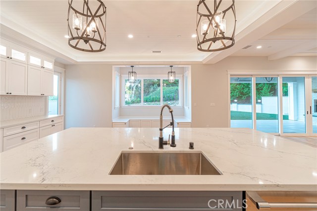 View of kitchen Quartzite counter tops and built-in breakfast nook, facing the backyard.