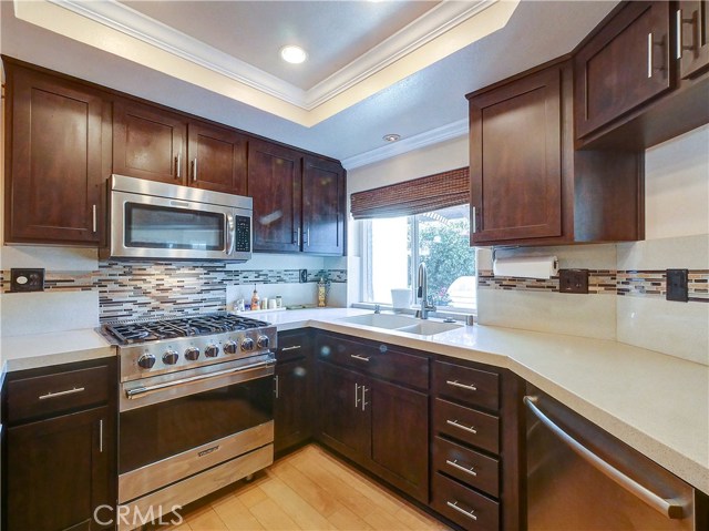 Updated kitchen with solid surface countertops and glass backsplashes.
