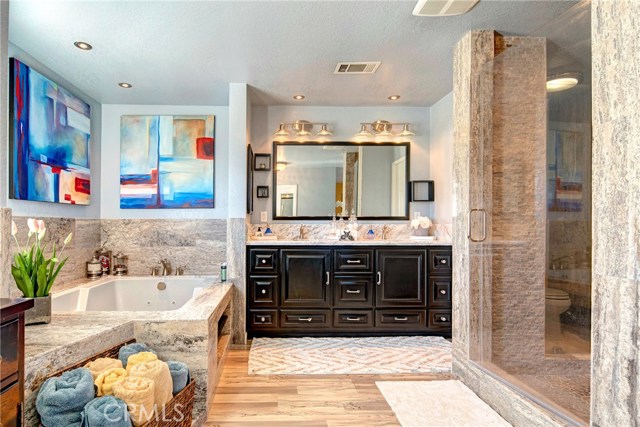 Masterfully updated resort level en-suite master bath with marble, jetted tub, dual sinks, designer vanity, and an absolutely stunning stone walk-in shower.