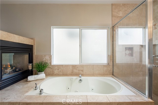 The master bathroom suite is highlighted by the elegant fireplace and features a large jetted tub, large shower, and customized walk-in closet.