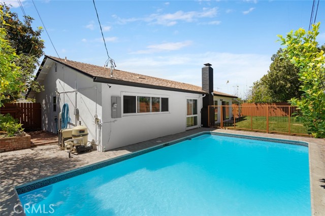 Picture of the pristine, newly renovated heated pool on one side and house in the background.  Mature fruit trees surrounding the pool and grass area over to one side.  Great for BBQ's and family gatherings.