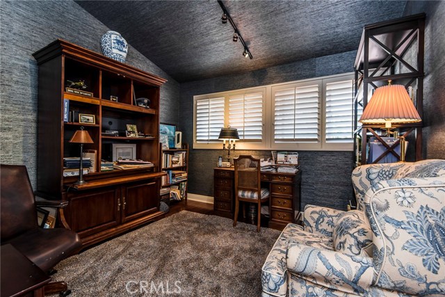 Entry level bedroom is currently being used as an office. Sophisticated wall coverings and plantation shutters create a gorgeous space for a guest or live-in relative. A remodeled 3/4 guest bathroom is conveniently nearby