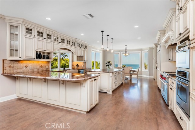 Kitchen with large eat at bar, large island and bay windows with ocean view