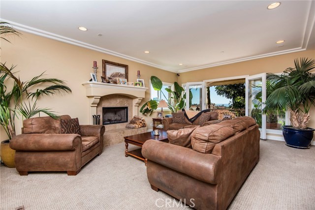 Living room with fireplace and deck with ocean views. Home is currently unfurnished,