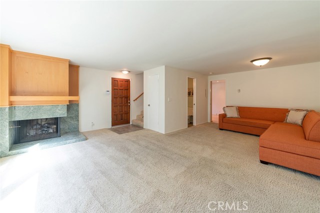 Spacious light and bright Living - Room featuring granite surround gas burning fireplace. Powder room and entrance to the remodeled kitchen