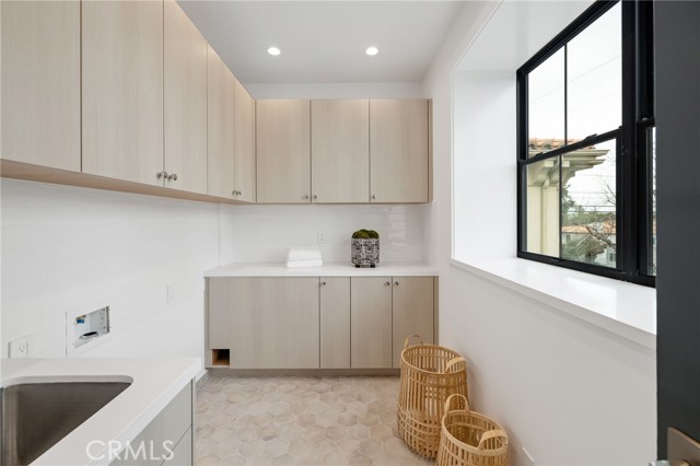 Bright and sunny second level laundry room with sink and so much storage