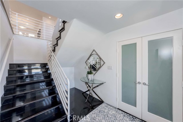 Front entrance stairway, black ceramic tile floor, dual door to closet