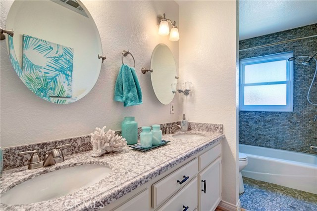 Updated, full, upstairs bath with granite counters, dual sinks, stone flooring and shower!