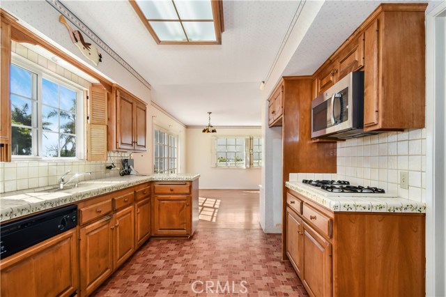 Kitchen has plenty of wood cabinets, counter space, gas stove, microwave, dishwasher, double oven