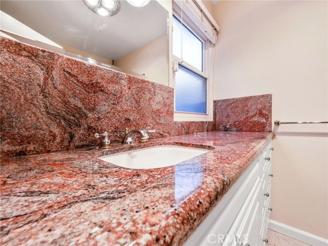 The remodeled master bathroom with large shower, granite finishes.