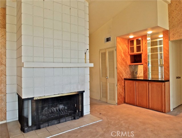 Wood burning fireplace with gas starter and dry bar in the living room.