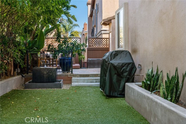 View of rear yard toward water feature, sitting area and patio door to the sunny breakfast area.