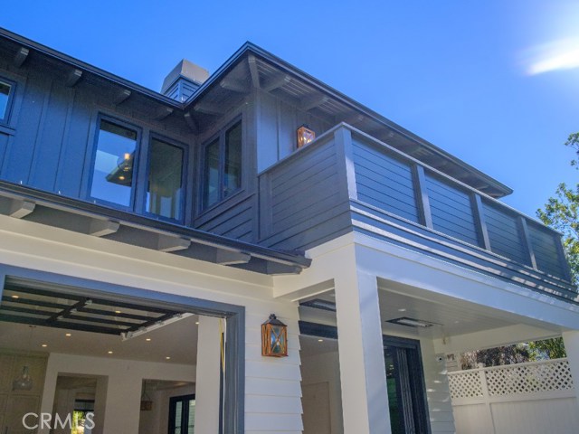 Backyard view of the home exterior. Features complete rain gutters. All Exterior Window Frames and Fixtures are topped with Copper to reduce corrosion from salt air and dew. Custom Wood Fence around the entire home with new block walls and custom stucco finish.