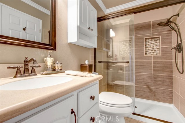 master bathroom has a nicely renovated walk in shower with custom tile, glass door enclosure, and oil rubbed bronze fixtures.