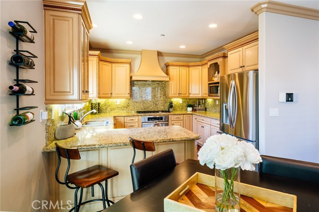 Beautiful kitchen featuring refined cabinetry, gorgeous granite counter tops, stainless steel appliances, ample storage and counter space, and open to the living room.