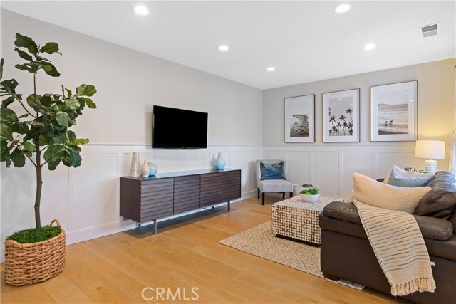 The bright and open great room includes custom wide plank French oak floors and wainscoting that bring warmth and character to the space.