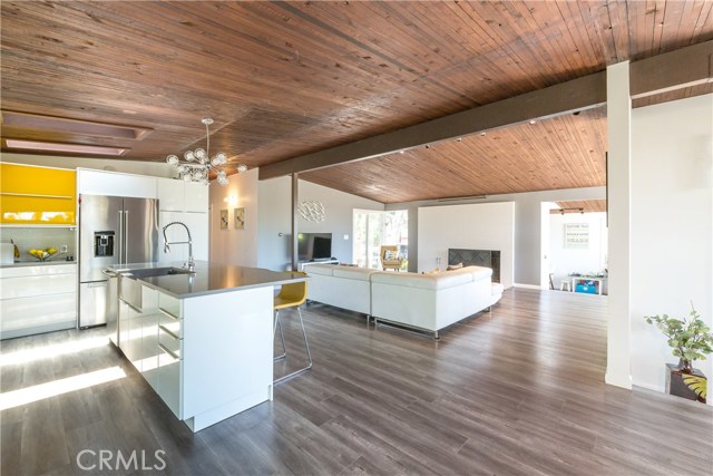 View of kitchen to family room with fireplace and den/office beyond