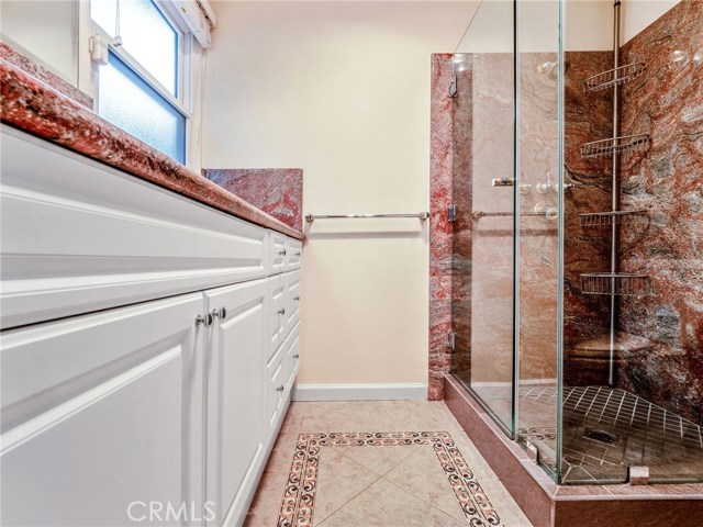 The remodeled master bathroom with large shower, granite finishes.