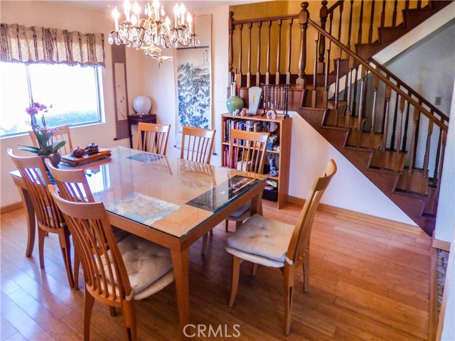 Beautiful dining room with chandelier, laminated wood floor  and large window