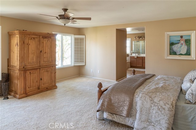 Large master bedroom with view of palm trees in back yard