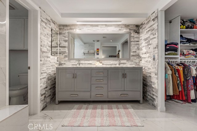 Oversized primary bath w stacked stone walk in closet