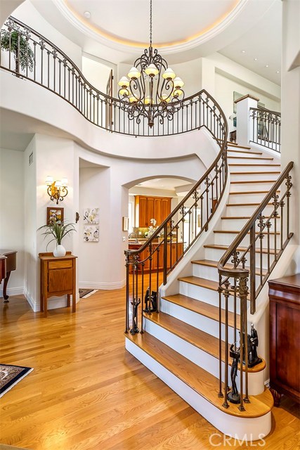 Graceful winding staircase feature custom-designed iron railings and matching light fixtures.