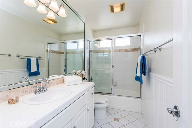 Bright, like-new full bathroom on second floor with wainscoting and bright white tile accented with marble.