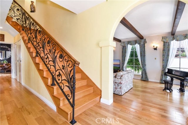 Stairwell off entry with beautiful wrought iron hand rails.